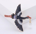 Broche - flyvende stork med gave til en heldig
