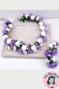 Blomsterkrans med roser og silkebånd i lilla/hvid med lille corsage 